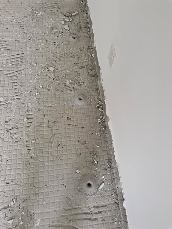 施工中建筑的墙脚边，一排钻好的注药孔。